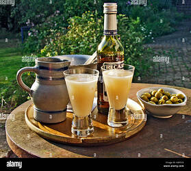 two-glasses-of-pernod-type-drink-being-poured-in-evening-sunshine-A3P1C8