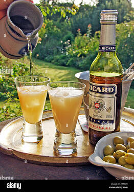 two-glasses-of-pernod-type-drink-being-poured-in-evening-sunshine-A3P1C5
